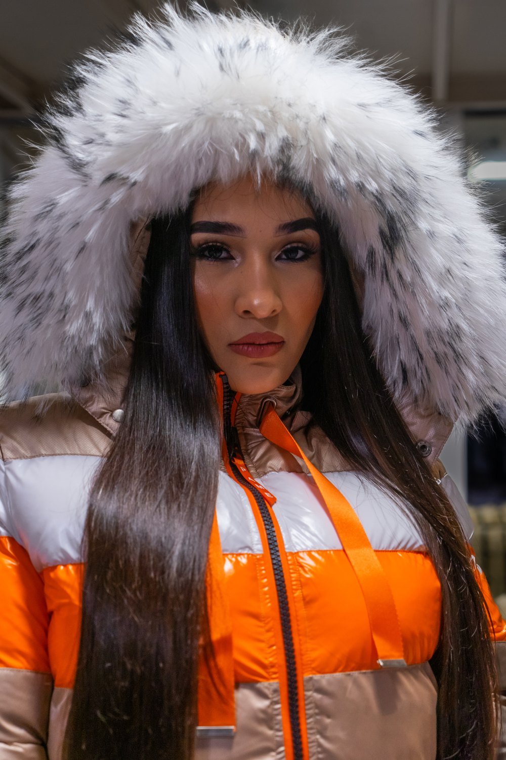 Retrato de moda con chaqueta naranja y capucha blanca