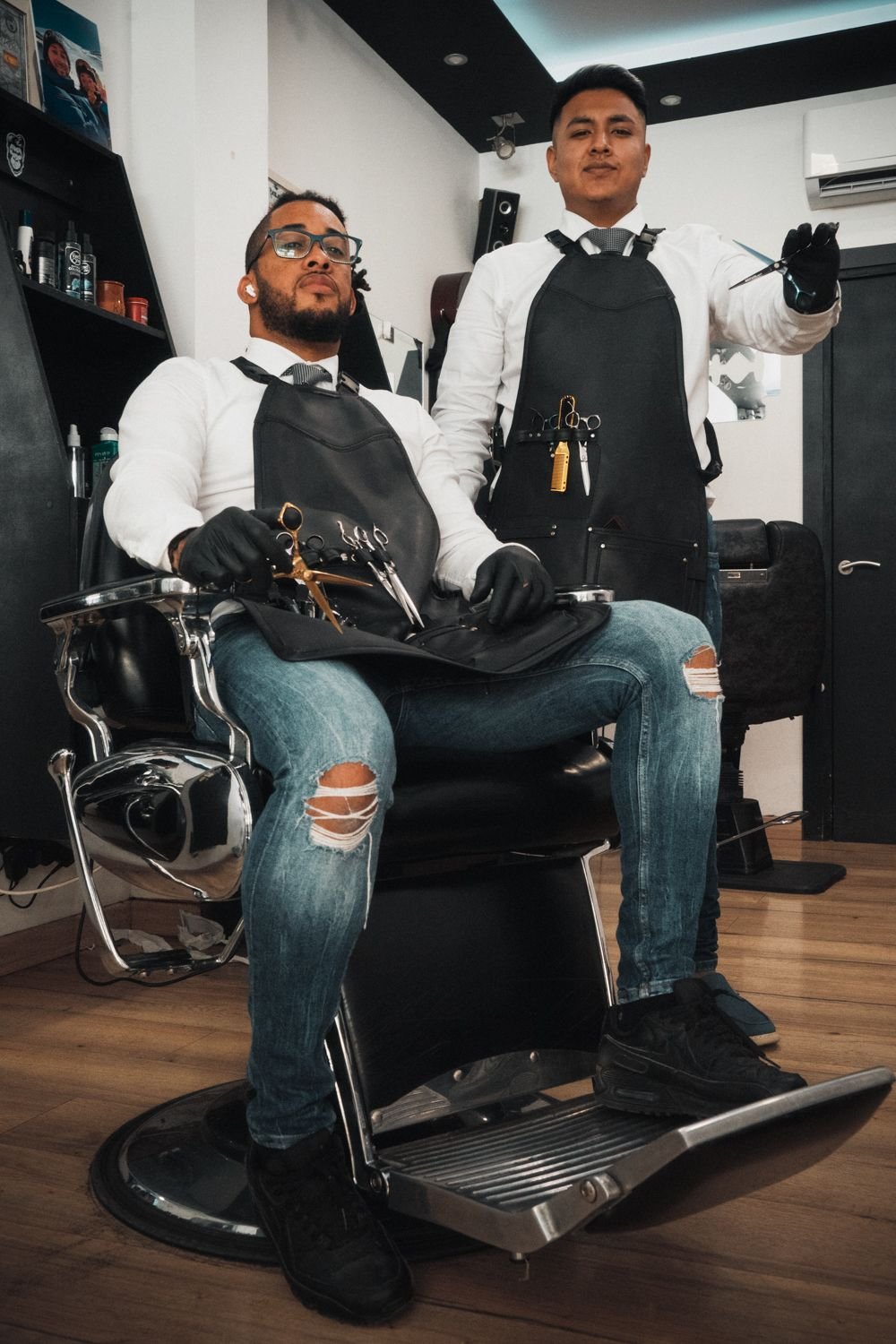 Dos profesionales retratados en el interior de una barbería
